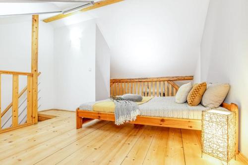 1 dormitorio con cama de madera y almohadas en Utulny a prostorny podkrovni byt s krbovymi kamny, en České Budějovice