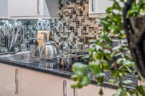 a kitchen sink with pots and pans on it at Stylish Central Edinburgh Abode in Edinburgh