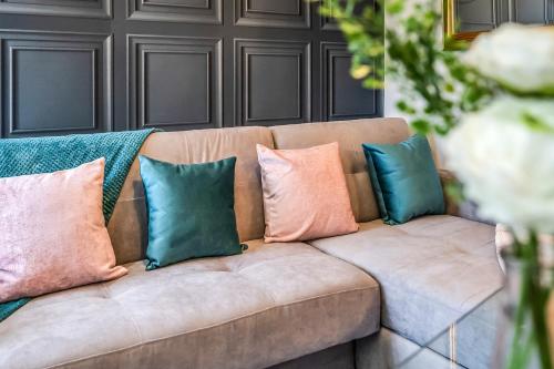 a brown couch with four pillows on it at Stylish Central Edinburgh Abode in Edinburgh