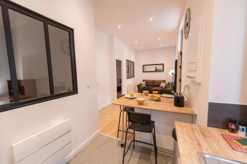 une cuisine et un salon avec une table et un canapé dans l'établissement KASA LOFT CENTRE 2 - WIFI et TV - Confortable et stationnement gratuit à proximité, à Saint-Étienne