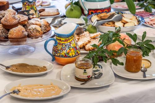 een tafel met borden met eten en desserts bij Agriturismo Val Di Noto in Noto