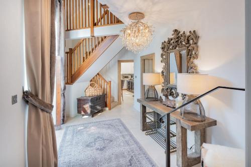 a living room with a staircase and a chandelier at Rose Walls in Stainton