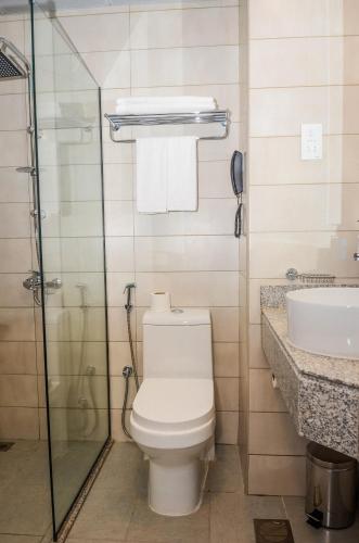 a bathroom with a toilet and a sink at VOGO Grand Hotel Formerly Best Western Plus Hotel Dubai Academic City in Dubai