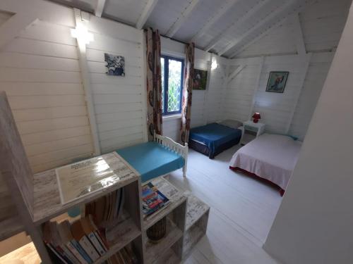 a room with a bed and a bench in a room at Tropical Dream - Gîte Touristique - 4Adultes et 3Enfants in Baie-Mahault
