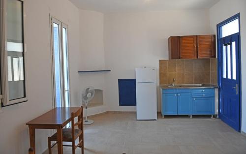 a kitchen with blue cabinets and a white refrigerator at Armenistis appartments with a view in Armenistis
