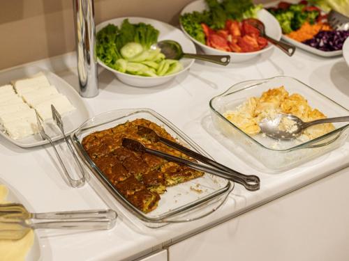 a table topped with dishes of food and bowls of vegetables at Boutique Hotel 32 in Batumi