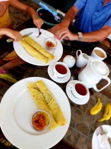 a table with plates of food and cups of tea at Chill House make a Good Story with infinite Ocean Surf and Stay in Weligama