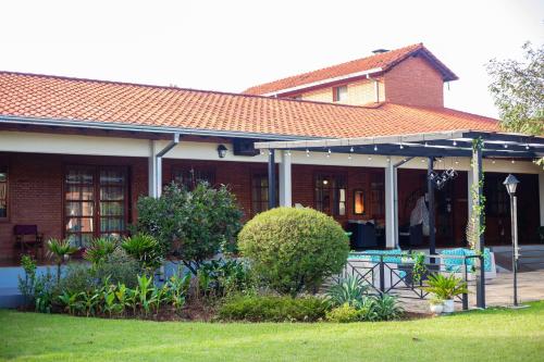 a brick house with a porch with blue chairs at Puma Resort Hotel in Doctor Juan León Mallorquín