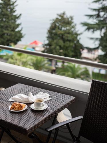 a table with a plate of food and a cup of coffee at Boutique Hotel 32 in Batumi