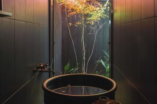 baño con bañera grande y ventana grande en Maana Kyoto, en Kioto