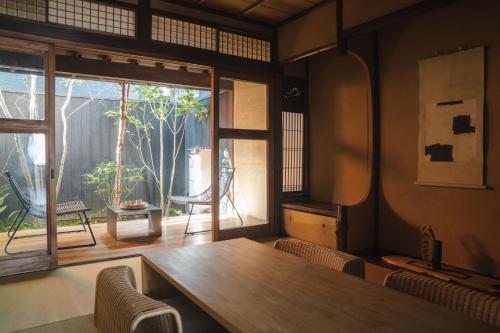 een eetkamer met een tafel en een raam bij Maana Kyoto in Kyoto