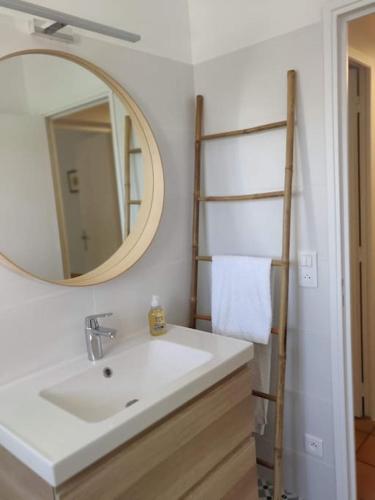 une salle de bain avec un lavabo et un miroir dans l'établissement La Maison de Colette - Coeur de village, à Cuxac-dʼAude