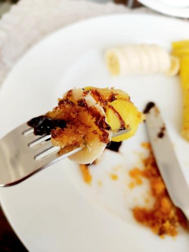 a piece of dessert on a white plate with a fork at Chill House make a Good Story with infinite Ocean Surf and Stay in Weligama