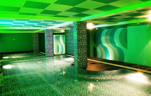 una camera con pista da bowling e luci verdi di Hotel Maximillian a Tanjung Balai Karimun