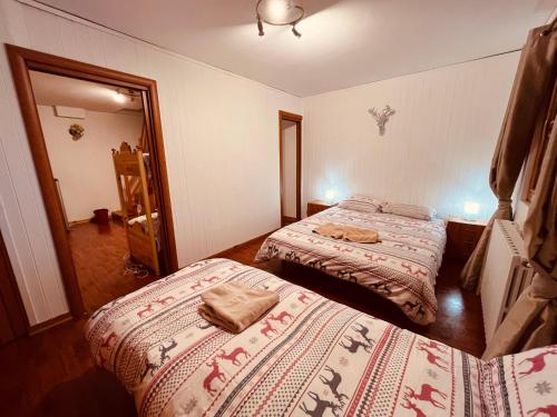 a bedroom with two beds and a mirror at La Baita Limone Riserva Bianca Ski-in Ski-out Seggiovia Morel 2 in Limone Piemonte