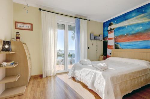 1 dormitorio con 1 cama y una pintura de un faro en Villa Alcaidesa Vistas al Mar en San Roque