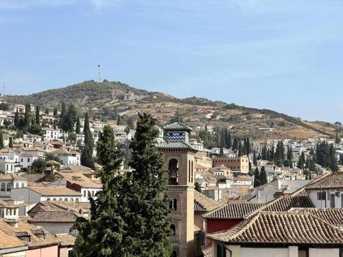 a large building with a clock tower in a city at Hostal Viena Plaza Nueva in Granada