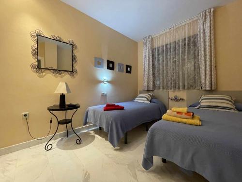 a bedroom with two beds and a mirror on the wall at B2 Bajo con terraza de 32 m2 en Playa Granada in Motril