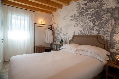 a bedroom with a white bed and a wall mural at Relais La Dolce Vite in San Vendemiano