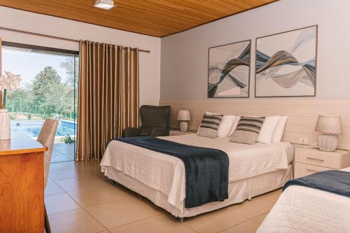 sypialnia z łóżkiem, krzesłem i oknem w obiekcie Puma Resort Hotel w mieście Doctor Juan León Mallorquín