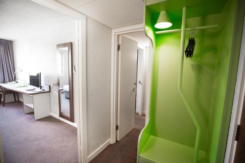 een kamer met een groene muur en een bureau bij Campanile Bradford in Bradford