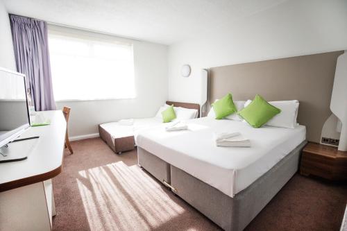 a hotel room with two beds and a television at Campanile Bradford in Bradford