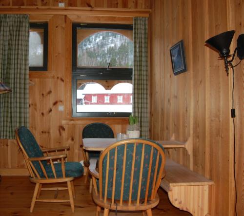 a dining room with a table and chairs and a window at Nisser Hyttegrend og Camping in Fjone