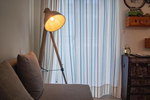 a floor lamp in a living room next to a couch at My Bed in pico in Madalena