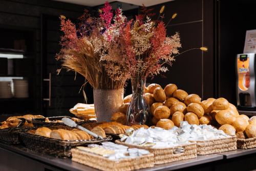 a table topped with lots of different types of bread at Cosmopolite Hotel Nieuwpoort-Bad in Nieuwpoort