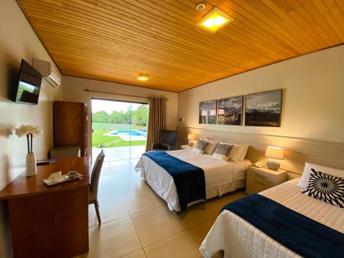 Pokój hotelowy z 2 łóżkami, biurkiem i oknem w obiekcie Puma Resort Hotel w mieście Doctor Juan León Mallorquín