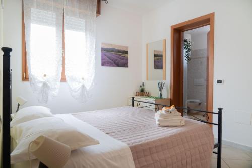 Schlafzimmer mit einem Bett mit weißer Bettwäsche und einem Fenster in der Unterkunft Residence Yellow in Rimini