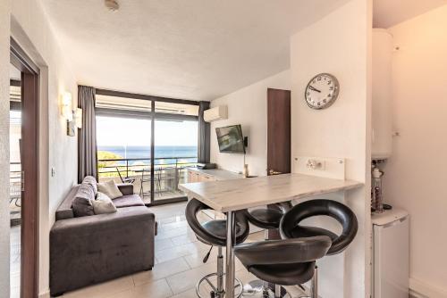 - un salon avec une table, des chaises et une horloge dans l'établissement Le Tino Rossi, à Ajaccio