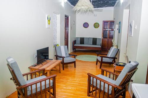 a living room with chairs and a table and a couch at Zanzibar Spice Nest Apartment in Stone Town