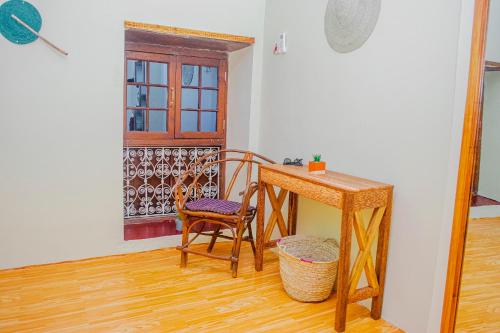 Zimmer mit einem Schreibtisch, einem Stuhl und einem Tisch in der Unterkunft Zanzibar Spice Nest Apartment in Stone Town