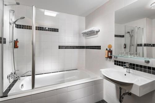 a white bathroom with a tub and a sink at Clarion Congress Hotel Ústí nad Labem in Ústí nad Labem