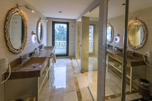 uma casa de banho com dois lavatórios e dois espelhos em Sinema Hotel Ordu em Ordu