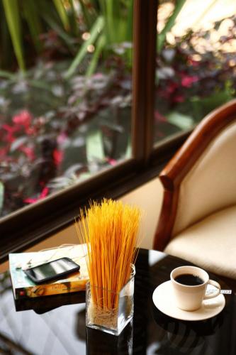 a table with a cup of coffee and some straws at The Palm Garden Hotel in Chiang Rai