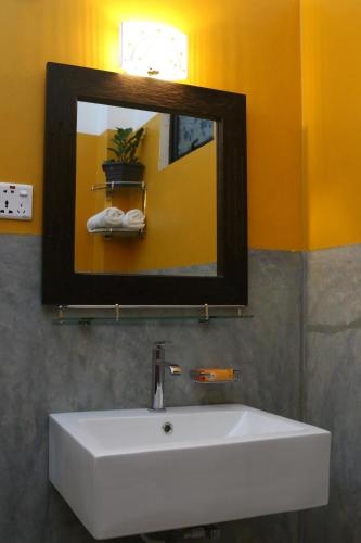 a bathroom with a white sink and a mirror at Villa Bird Gate in Galle