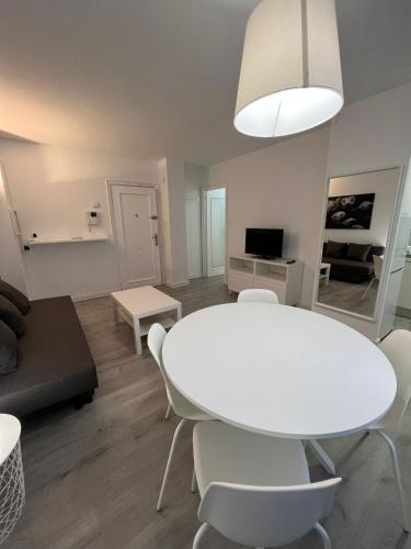 a white living room with a white table and chairs at Apartamento 1 dormitorio cerca hospitales in Zaragoza