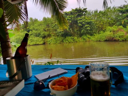 a table with a bottle of beer and a bowl of chips at Villa Bird Gate in Galle