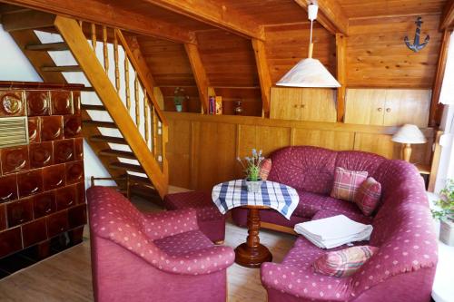 a living room with a purple couch and two chairs at Reetdachhaus in Quilitz auf Usedom in Quilitz