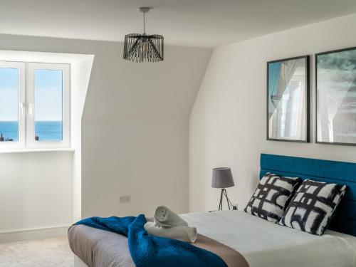 1 dormitorio con 1 cama con cabecero azul y ventana en Pass the Keys Heather Court Lovely 1 bedroom flat in Westbourne with parking, en Bournemouth