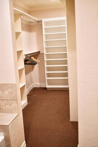 a walk in closet with white shelves and a hallway at Bountiful Heights in Bountiful