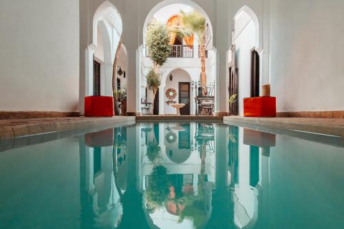 a pool of water in a room with a building at Riad Alwane in Marrakesh