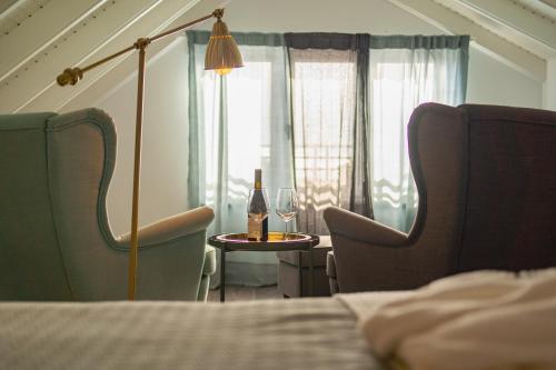 a room with a table with a bottle of wine and two chairs at My Bed in pico in Madalena