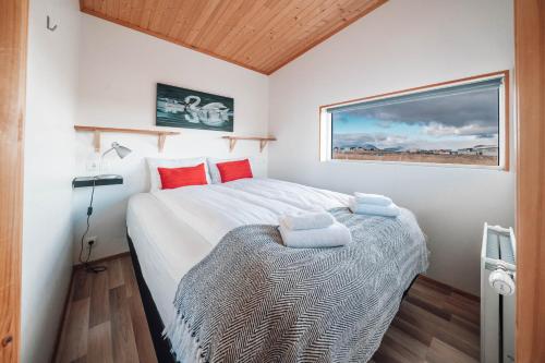 a bedroom with a large bed with red pillows at Blue View Cabin 7B With private hot tub in Selfoss