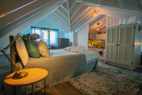 a bedroom with a bed and a table and a kitchen at My Bed in pico in Madalena