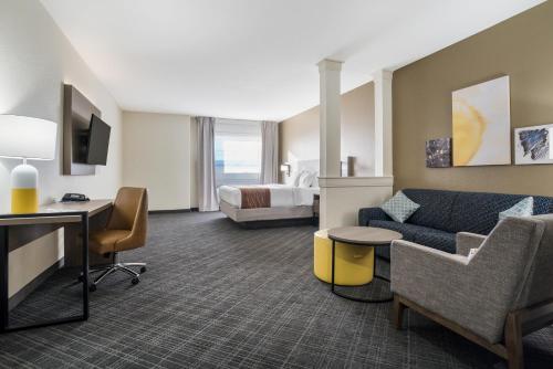 a hotel room with a couch and a bed at Comfort Inn & Suites Victoria North in Victoria