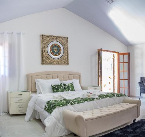 1 dormitorio blanco con 1 cama grande y 1 sofá en Garden House Pousada, Boutique & Spa, en São Roque