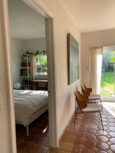 a bedroom with a bed and a chair and a window at Miami guest house with large pool in Miami